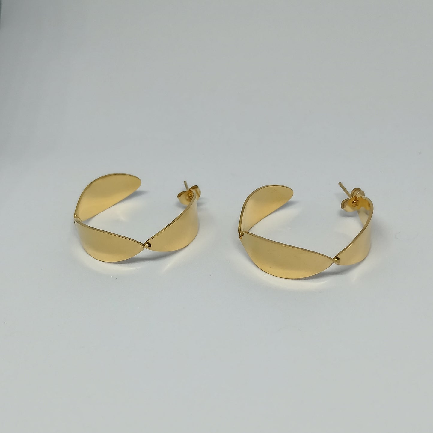 Pair of gold hoop earrings on a light gray background
