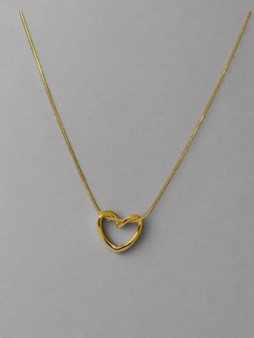 Gold heart-shaped necklace on a white background