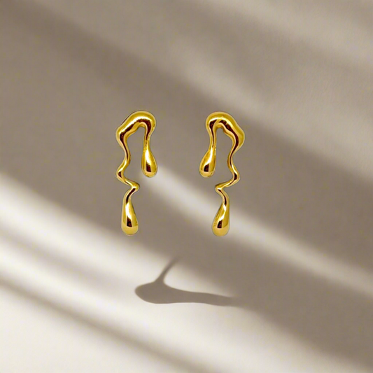 Gold abstract earrings on a white background