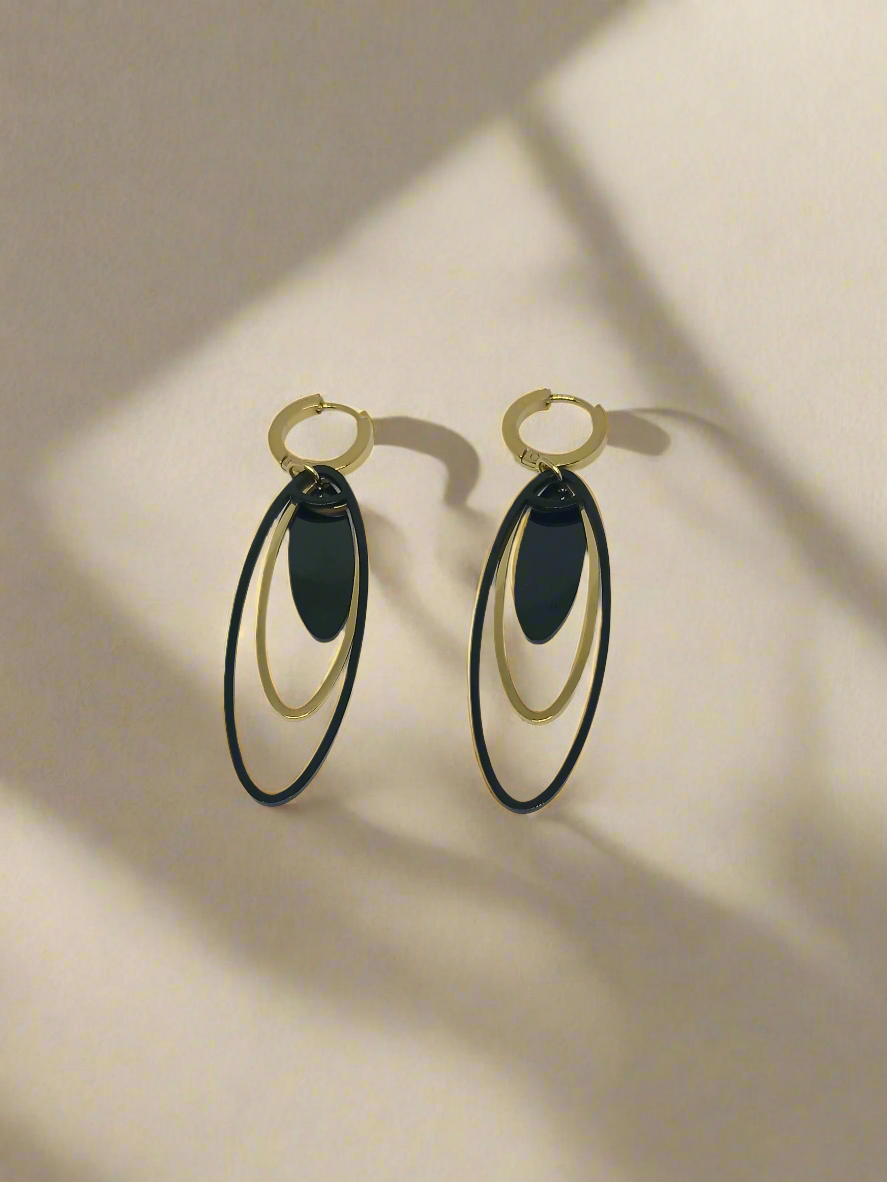 Pair of earrings with black and gold design on a white background