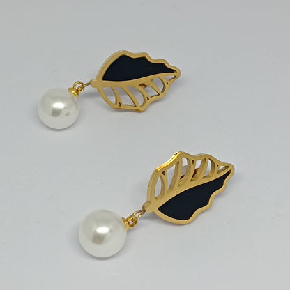 Pair of earrings with gold leaf design and pearl drops on a light gray background