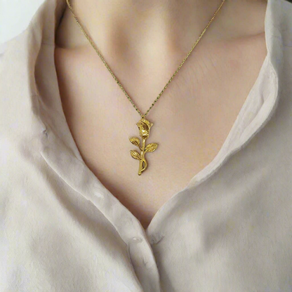 Gold rose-shaped pendant on a chain against a white background
