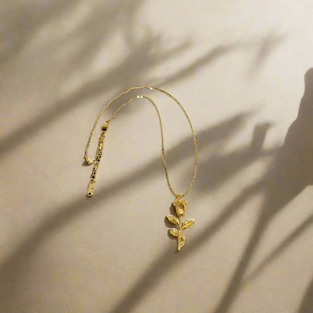 Gold necklace with a floral pendant on a white background