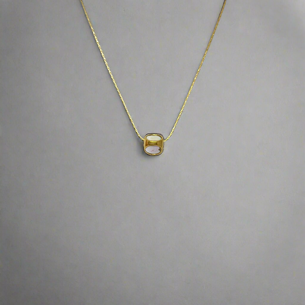 Gold necklace with a small round pendant on a white background