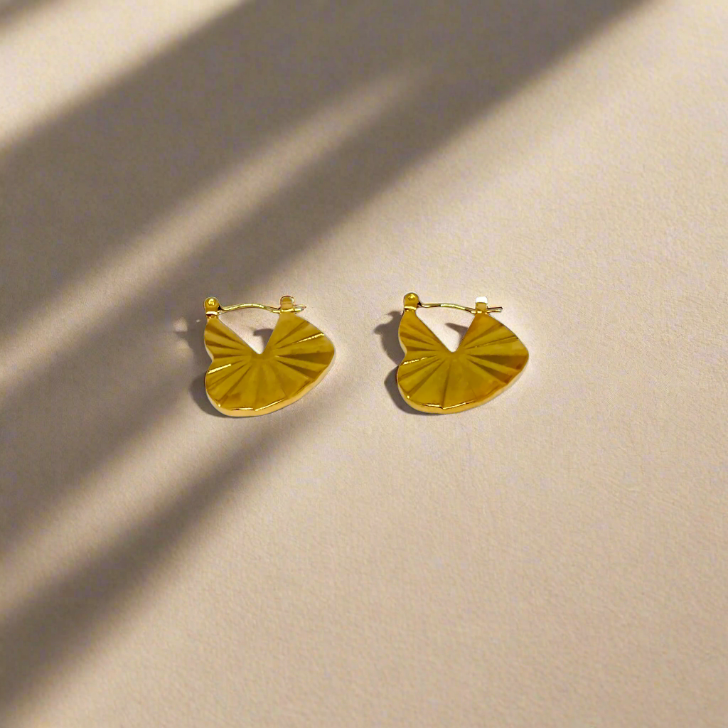 Heart Shaped Gold hoop earrings on a white background
