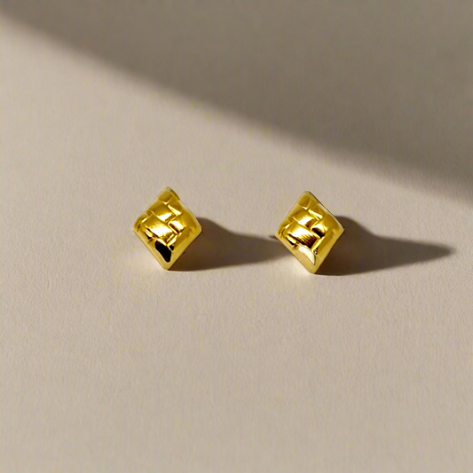 Two gold square-shaped beads on a white background