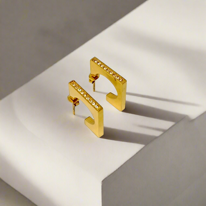 Gold earrings with small diamonds on a white background