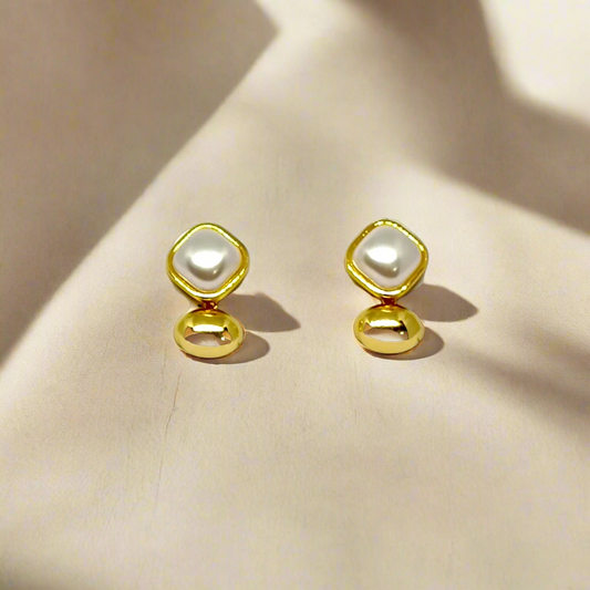 Pair of gold earrings with pearl-like centers on a white background
