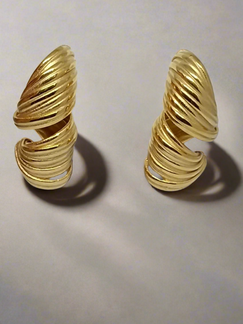 Pair of gold spiral earrings on a light gray background