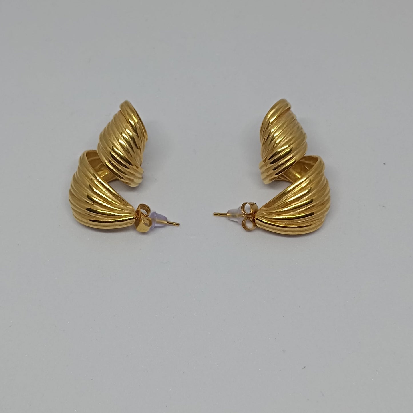 Pair of gold hoop earrings on a light gray background