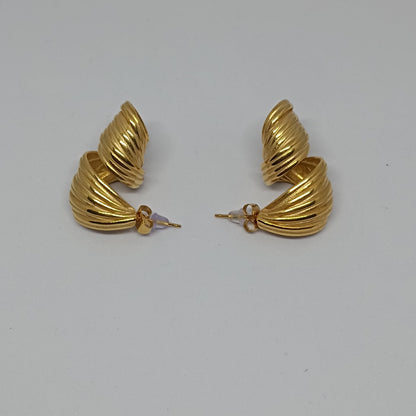 Pair of gold hoop earrings on a light gray background