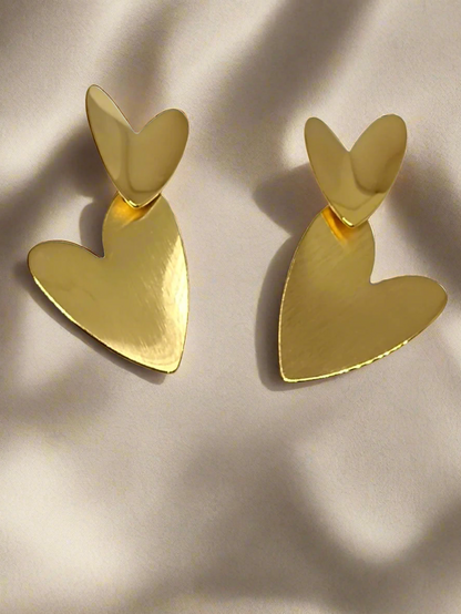 Gold heart-shaped earrings on a white card