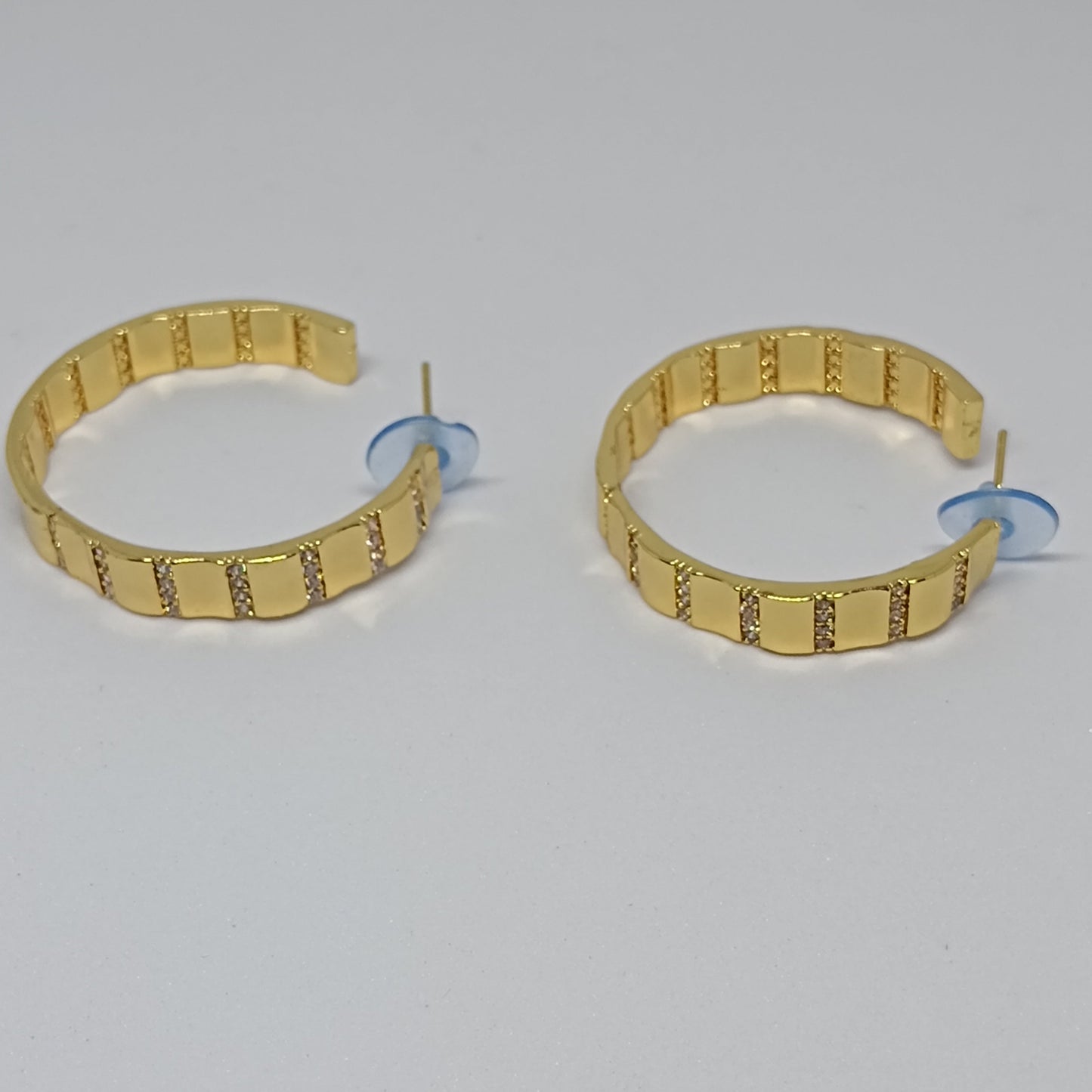 Gold hoop earrings on a gray background