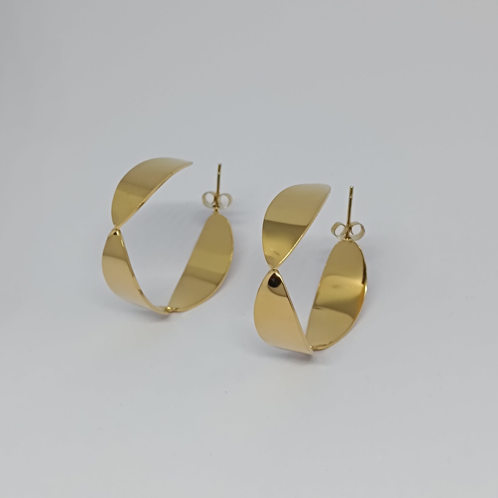 Gold hoop earrings on a light gray background