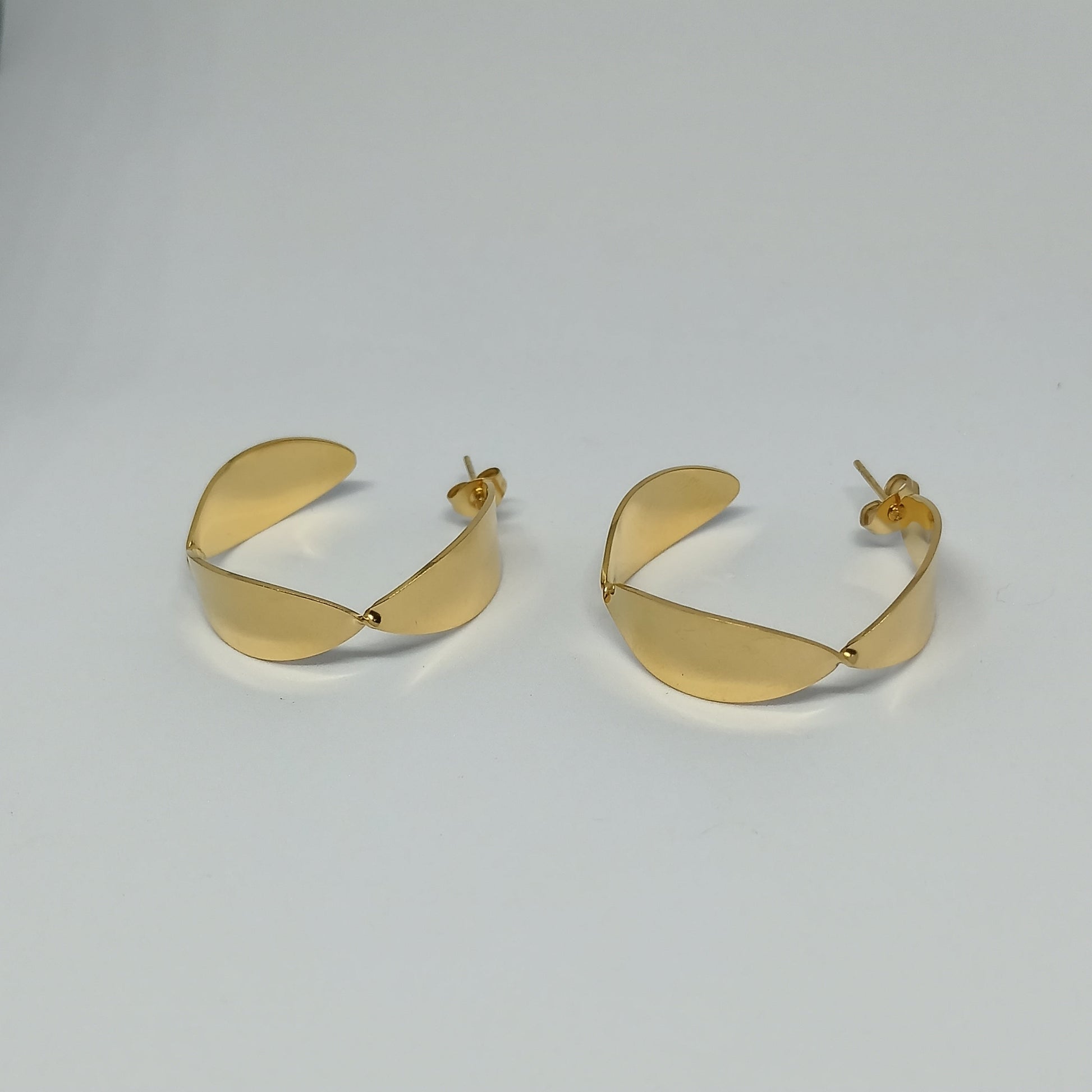 Pair of gold hoop earrings on a light gray background