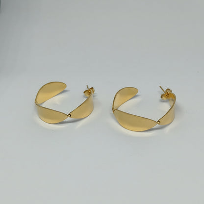 Pair of gold hoop earrings on a light gray background