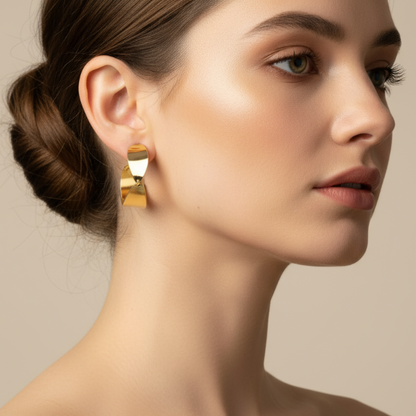 Woman wearing golden earrings with a neutral background