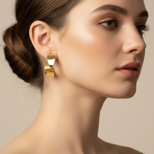 Woman wearing golden earrings with a neutral background