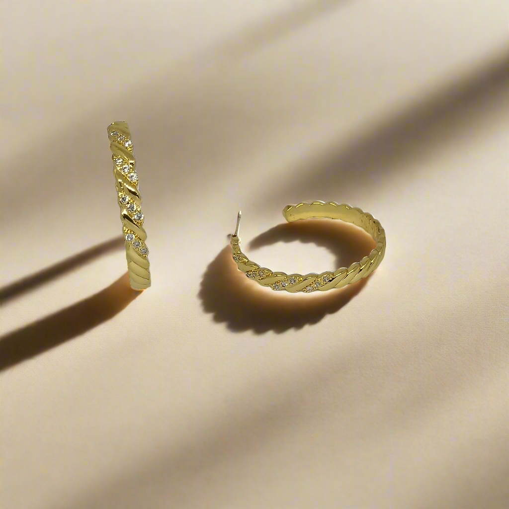Pair of gold hoop earrings on a light gray background