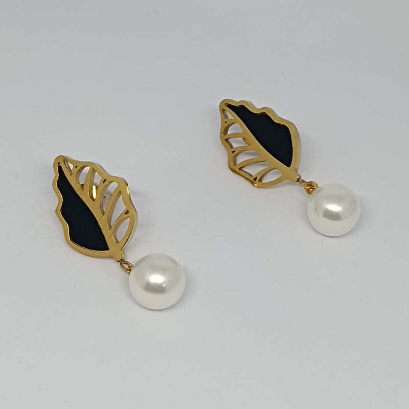 Gold leaf-shaped earrings with black centers and pearl drops on a light gray background
