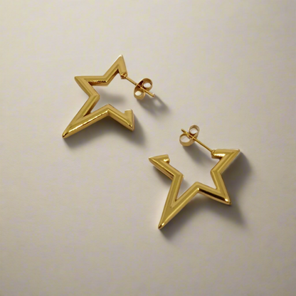 Gold star-shaped earrings on a light gray background