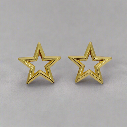 Gold star-shaped earrings on a light gray background