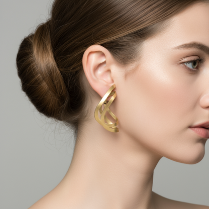 Close-up of a woman wearing a golden earring against a neutral background