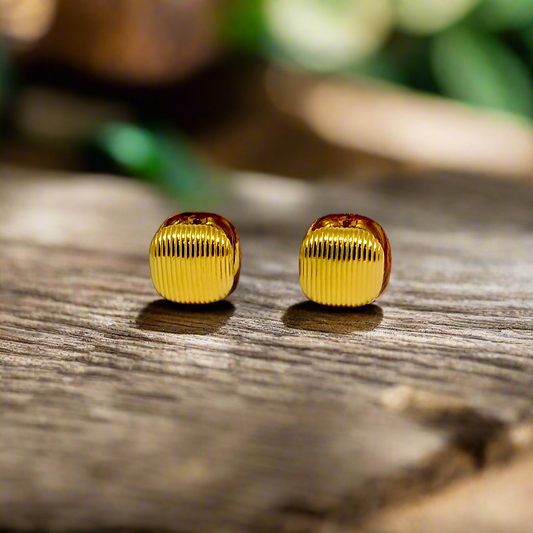 Pair of gold ribbed earrings on a white background