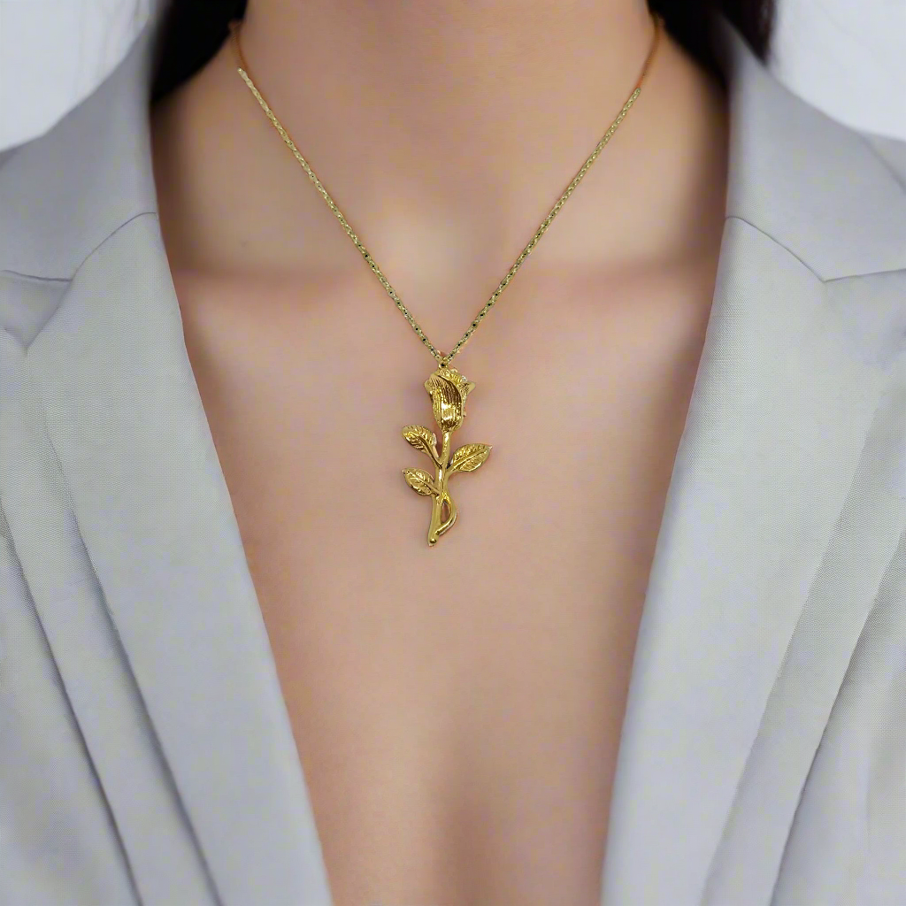 Gold rose-shaped pendant on a chain against a white background