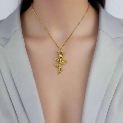 Gold rose-shaped pendant on a chain against a white background