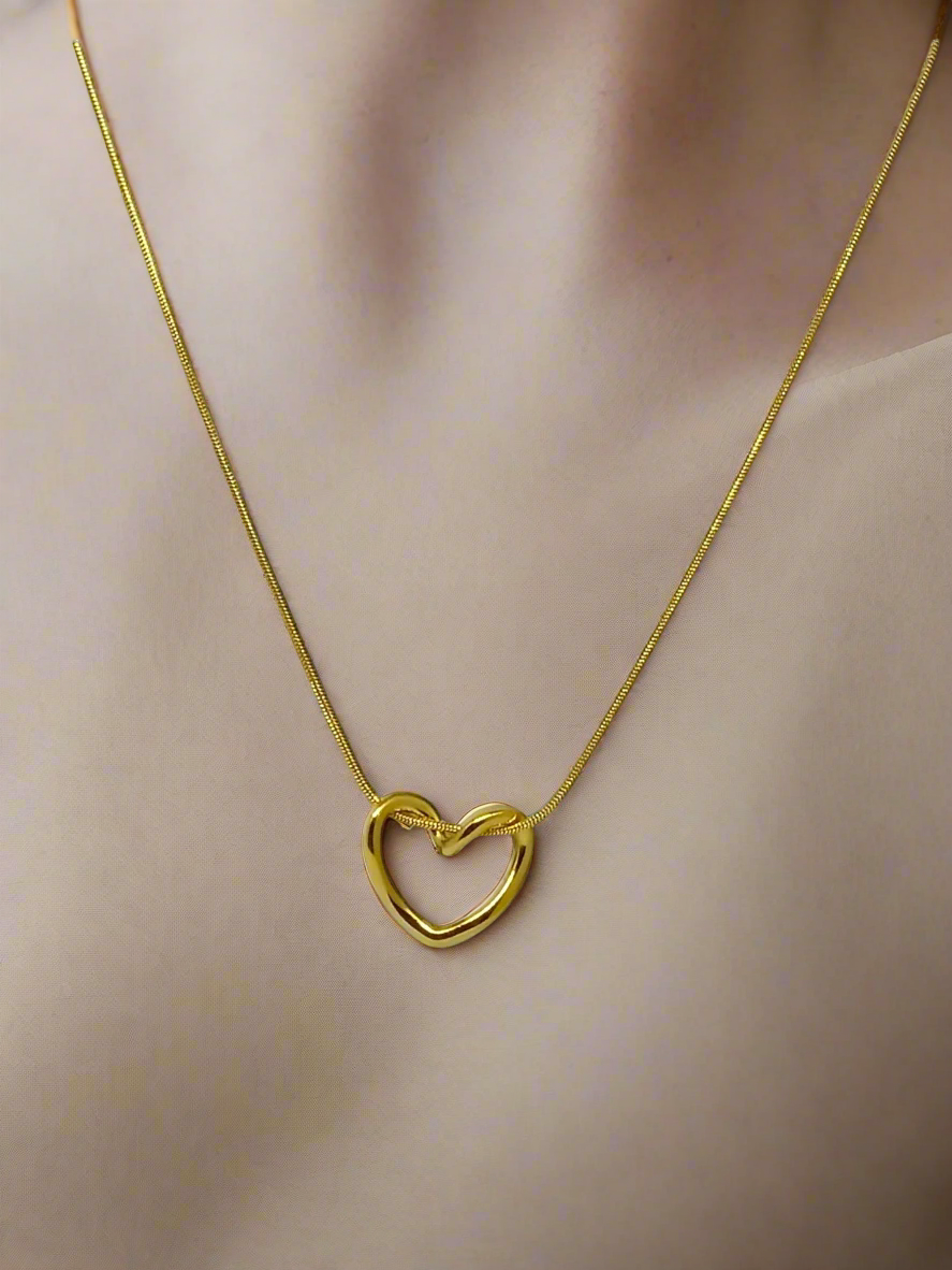 Gold heart-shaped necklace on a mannequin neck