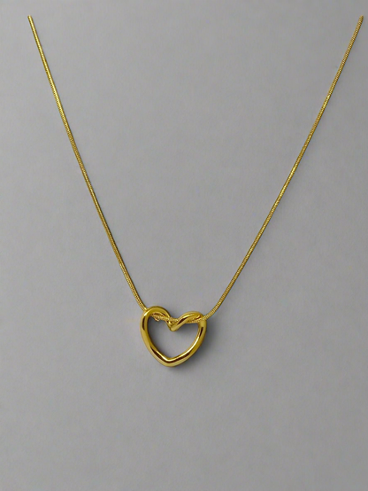 Gold heart-shaped necklace on a white background