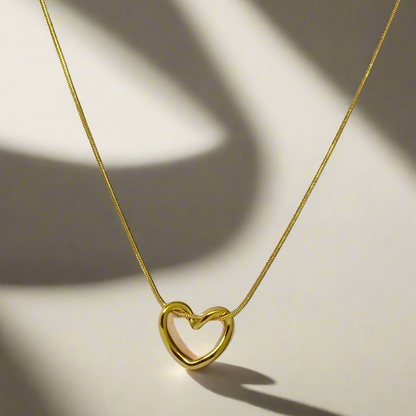 Gold heart-shaped necklace on a light background