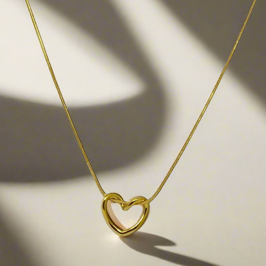 Gold heart-shaped necklace on a light background