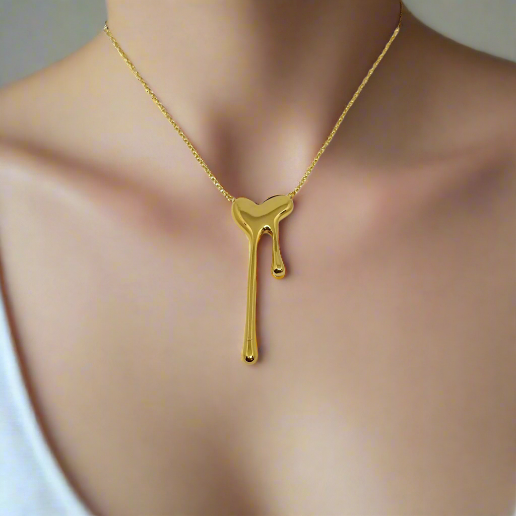 Gold necklace with a unique pendant on a white background