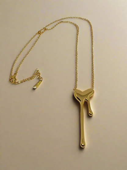 Gold necklace with a unique pendant on a light gray background