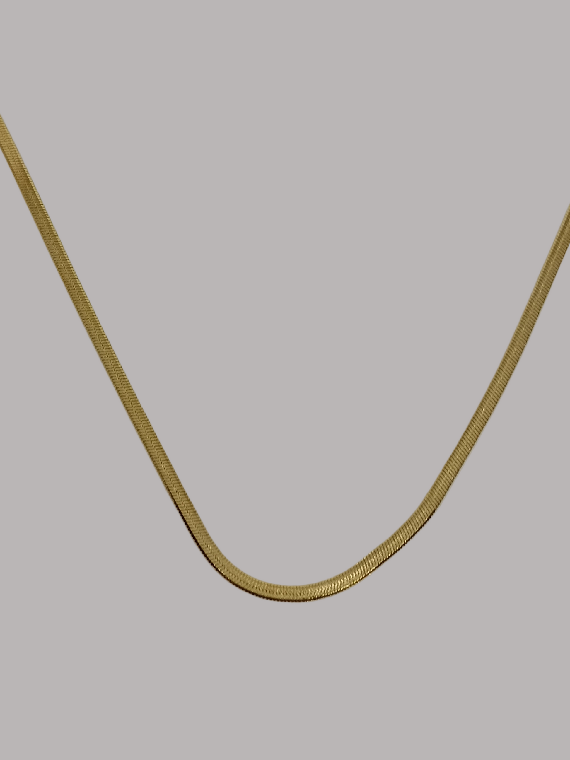 Gold chain on a light beige background