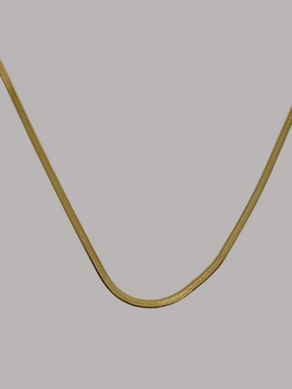 Gold chain on a light beige background