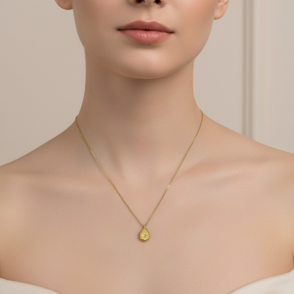 Golden necklace with a pendant worn by a model against a neutral background