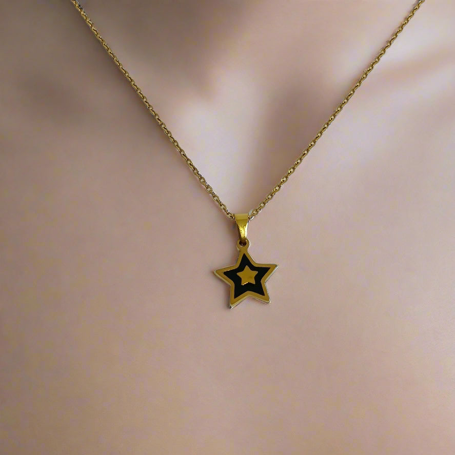 Gold star pendant necklace on a white card