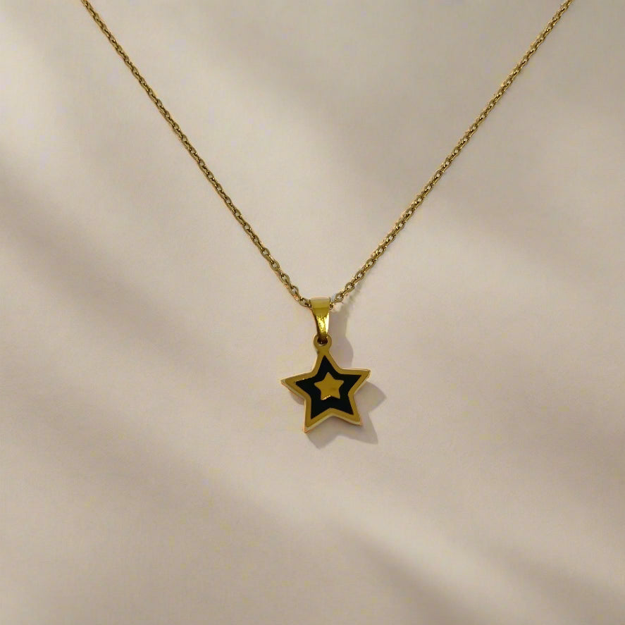 Gold star pendant necklace on a white card