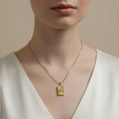 Golden necklace with a pendant on a model against a neutral background