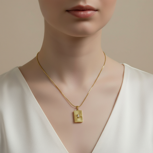 Golden necklace with a pendant on a model against a neutral background