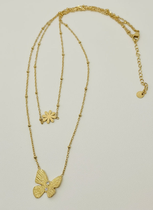 Gold necklace with a butterfly pendant on a light gray background
