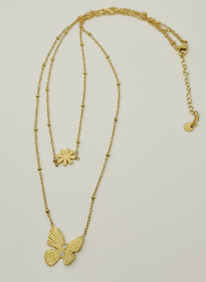 Gold necklace with a butterfly pendant on a light gray background