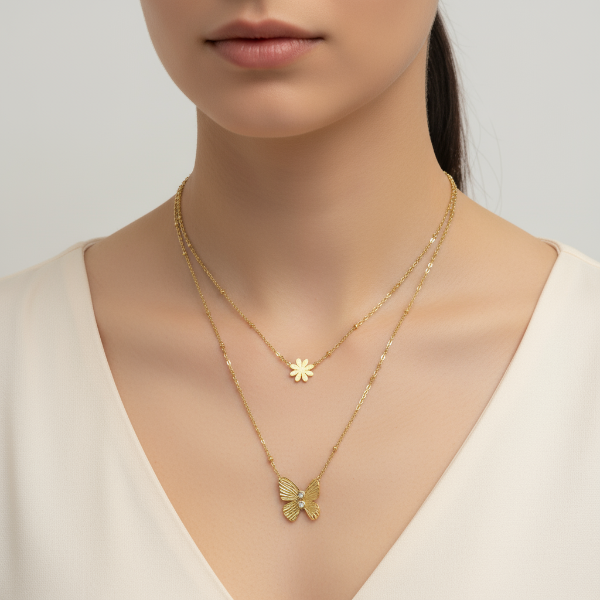 Golden necklace with butterfly pendant worn by a model on a plain background