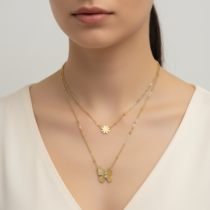 Golden necklace with butterfly pendant worn by a model on a plain background