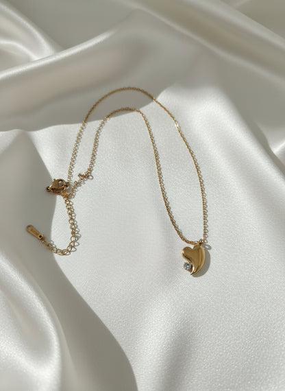 Gold necklace with a crescent moon pendant on a silk