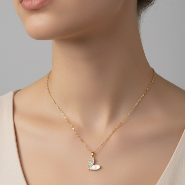 Gold necklace with a heart pendant on a neutral background