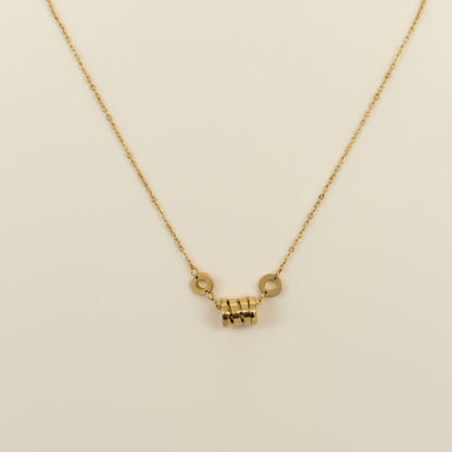 Gold necklace with a small pendant on a white background